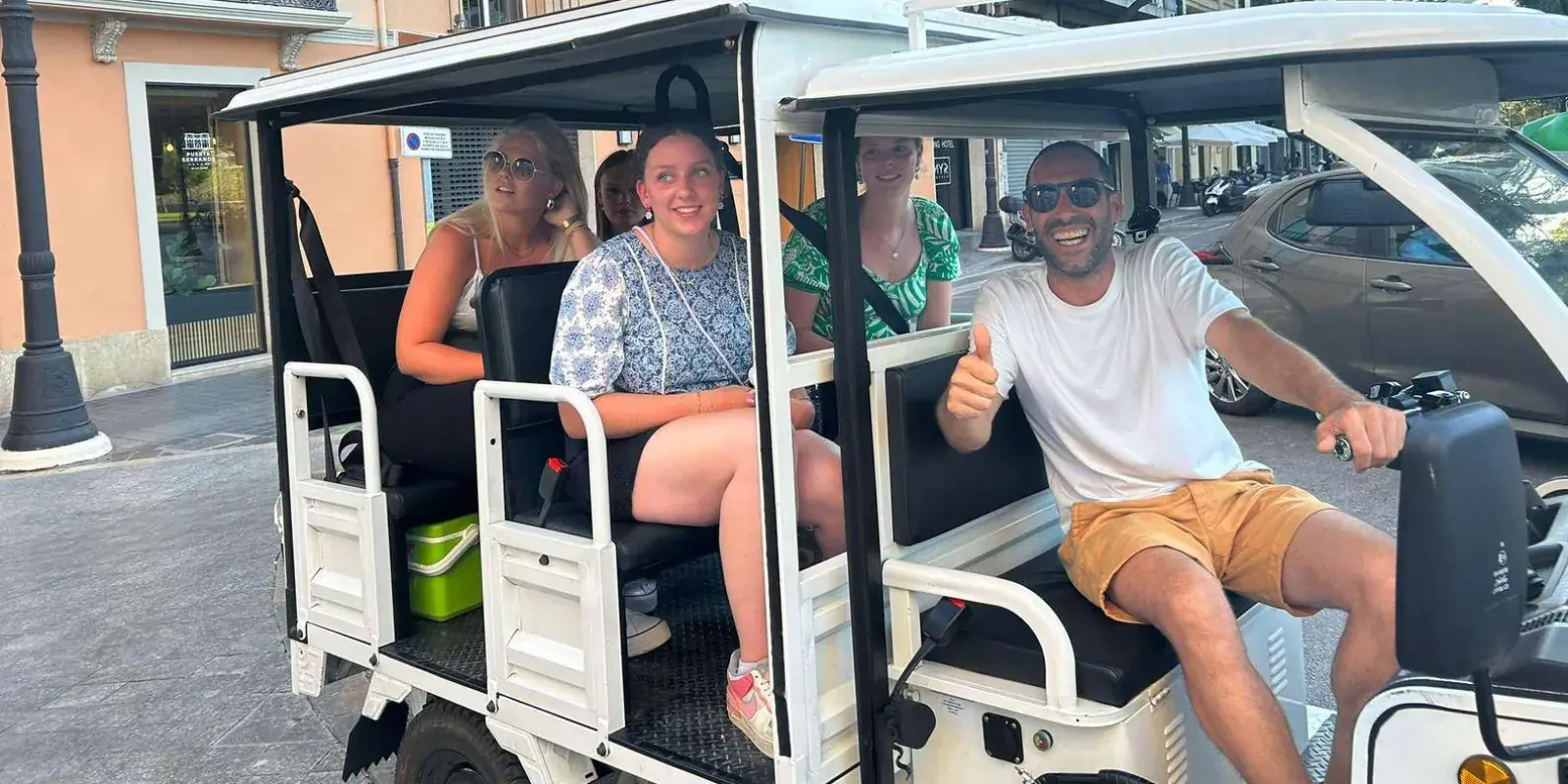 Travellers seated in white electric tuk tuks