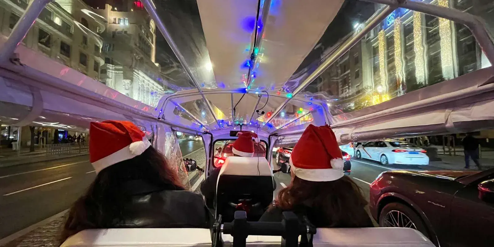 View from a tuk tuk beneath festive street lights