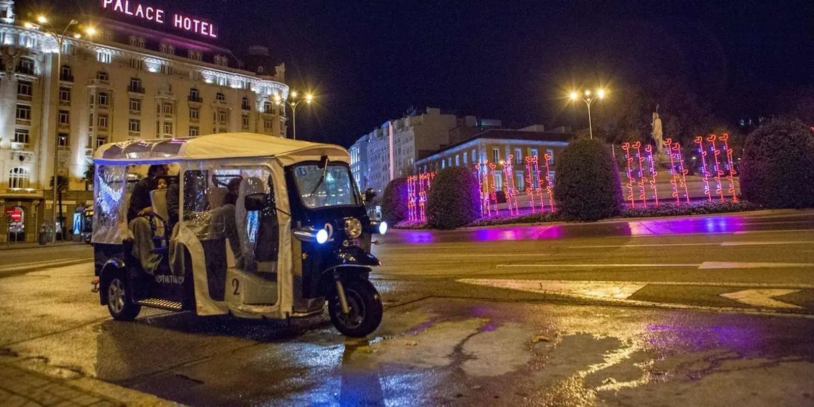Tuk tuk near a lit fountain during the evening