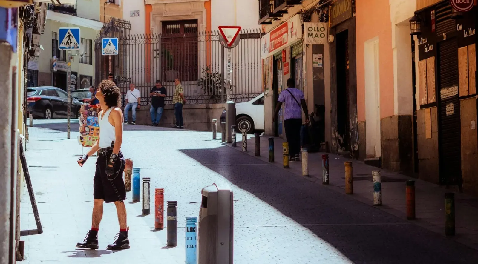 Pedestrians exploring a sunlit street in Madrid